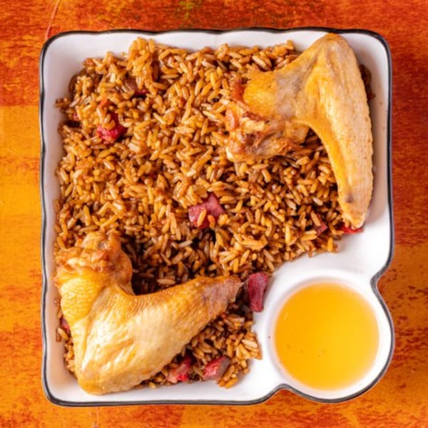 Chow n Joy's Chinese fried rice with two chicken wings and a side of sauce.