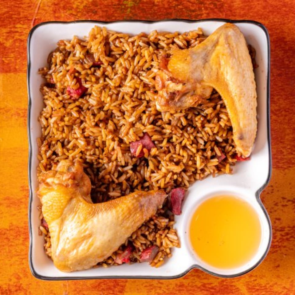 Chow n Joy's Chinese fried rice with two chicken wings and a side of sauce.