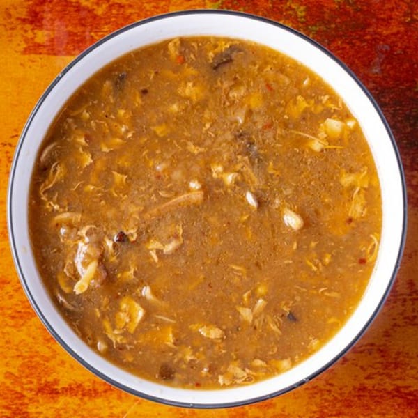 A bowl of Chow n Joy's Chinese hot and sour soup with chicken and vegetables.
